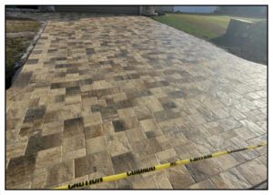 A brown and creme color tile job in the driveway