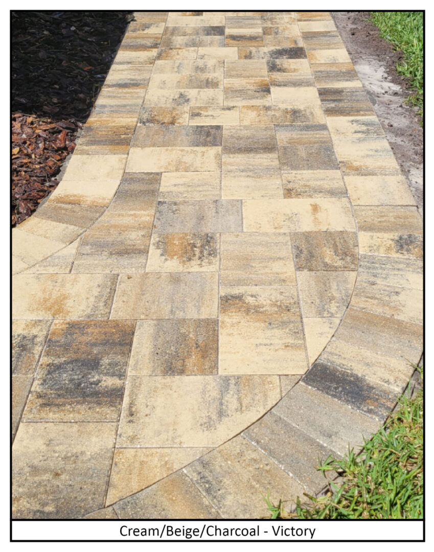 A stone walkway with grass and mulch.