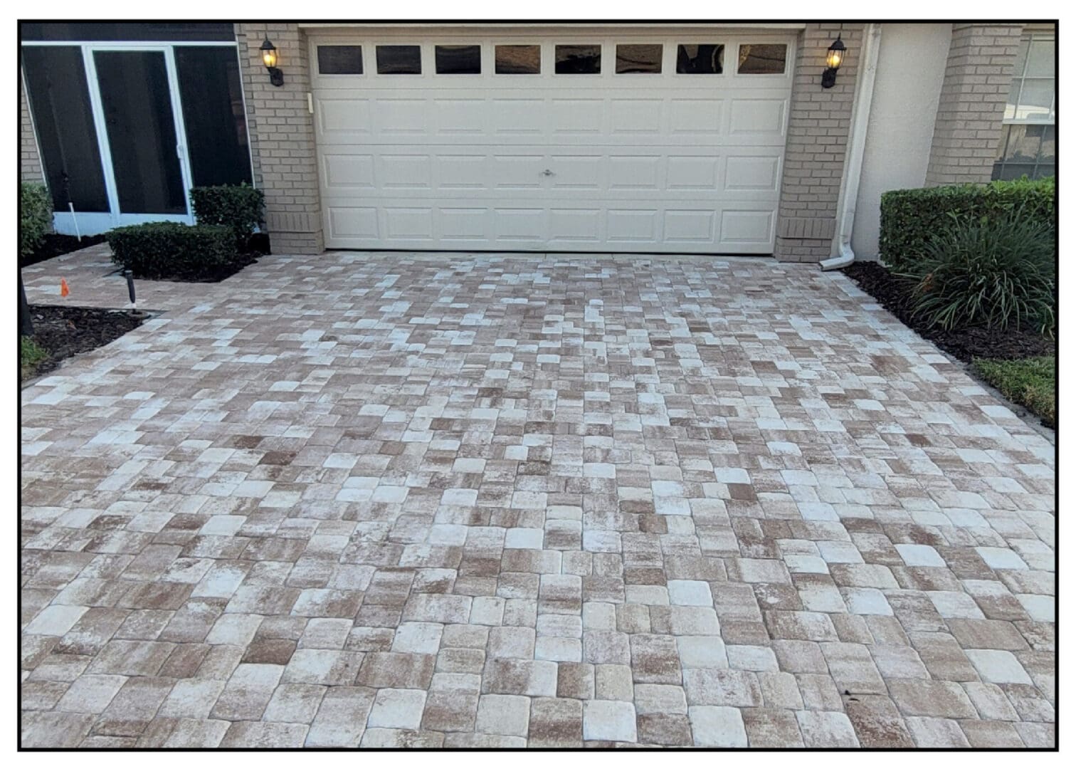 A driveway with brick pavers and a garage.