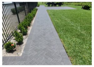 Brick walkway next to a green lawn.