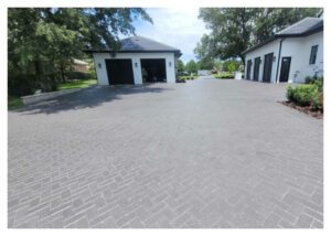 Brick driveway in front of a garage.