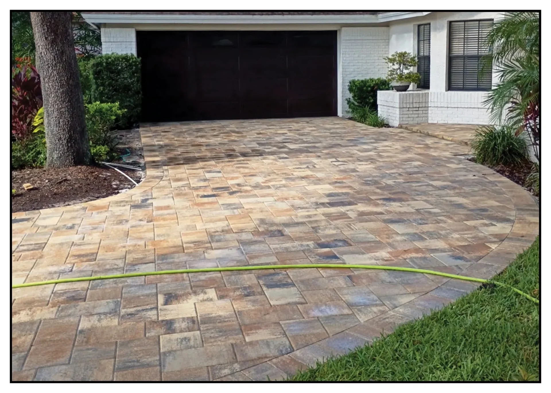 Paved driveway with garage and garden view.